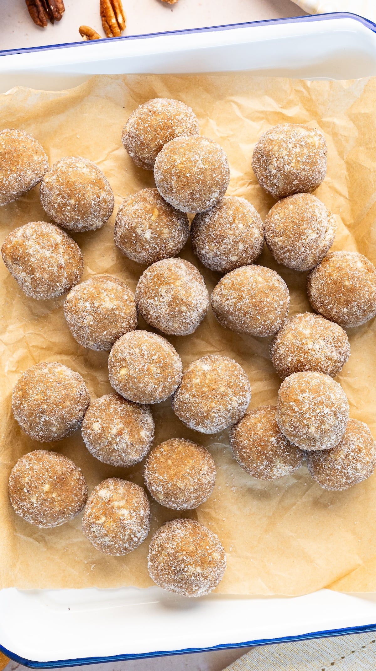 sugar-coated rum balls piled on parchment lined tray