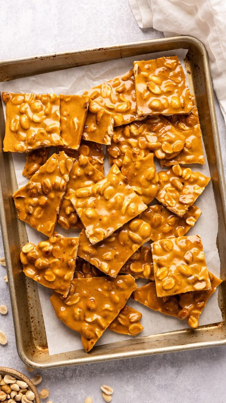 pieces of peanut brittle on parchment-lined baking sheet