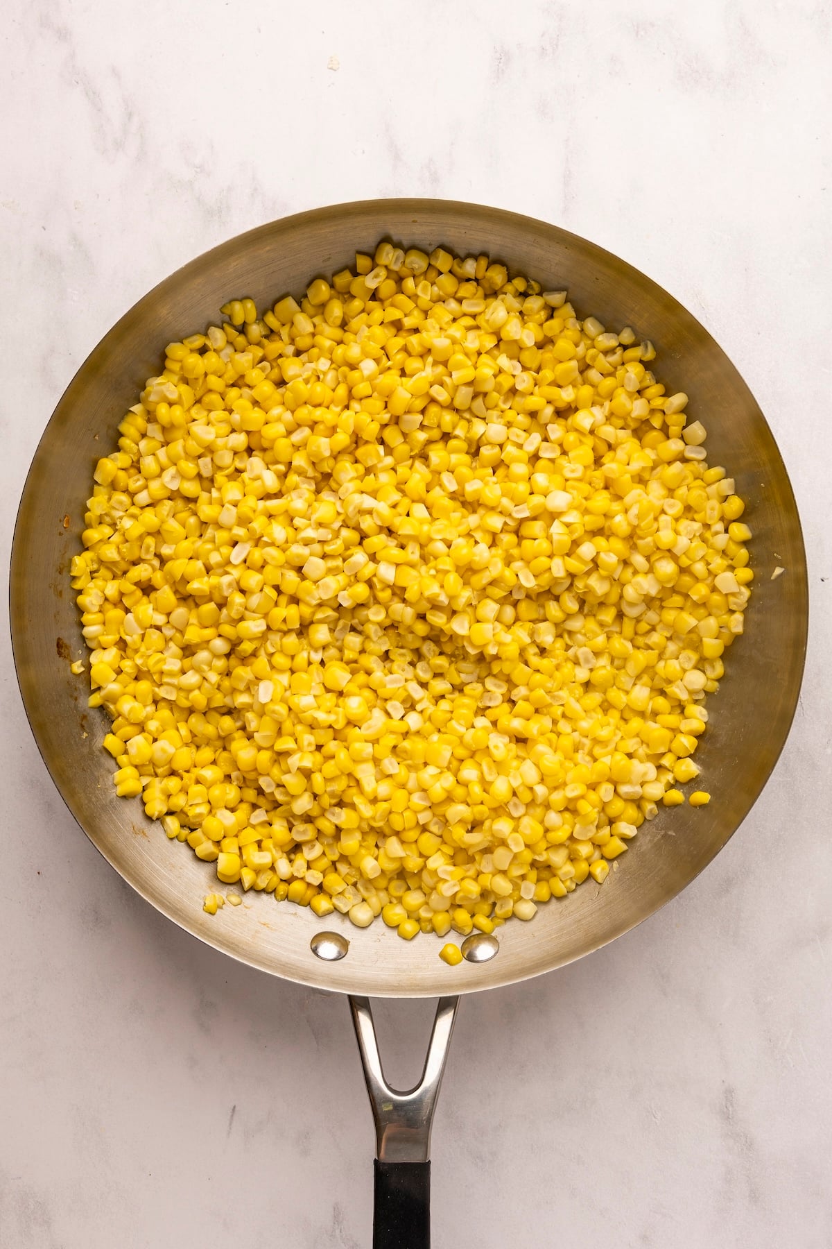 large skillet with cooked corn kernels