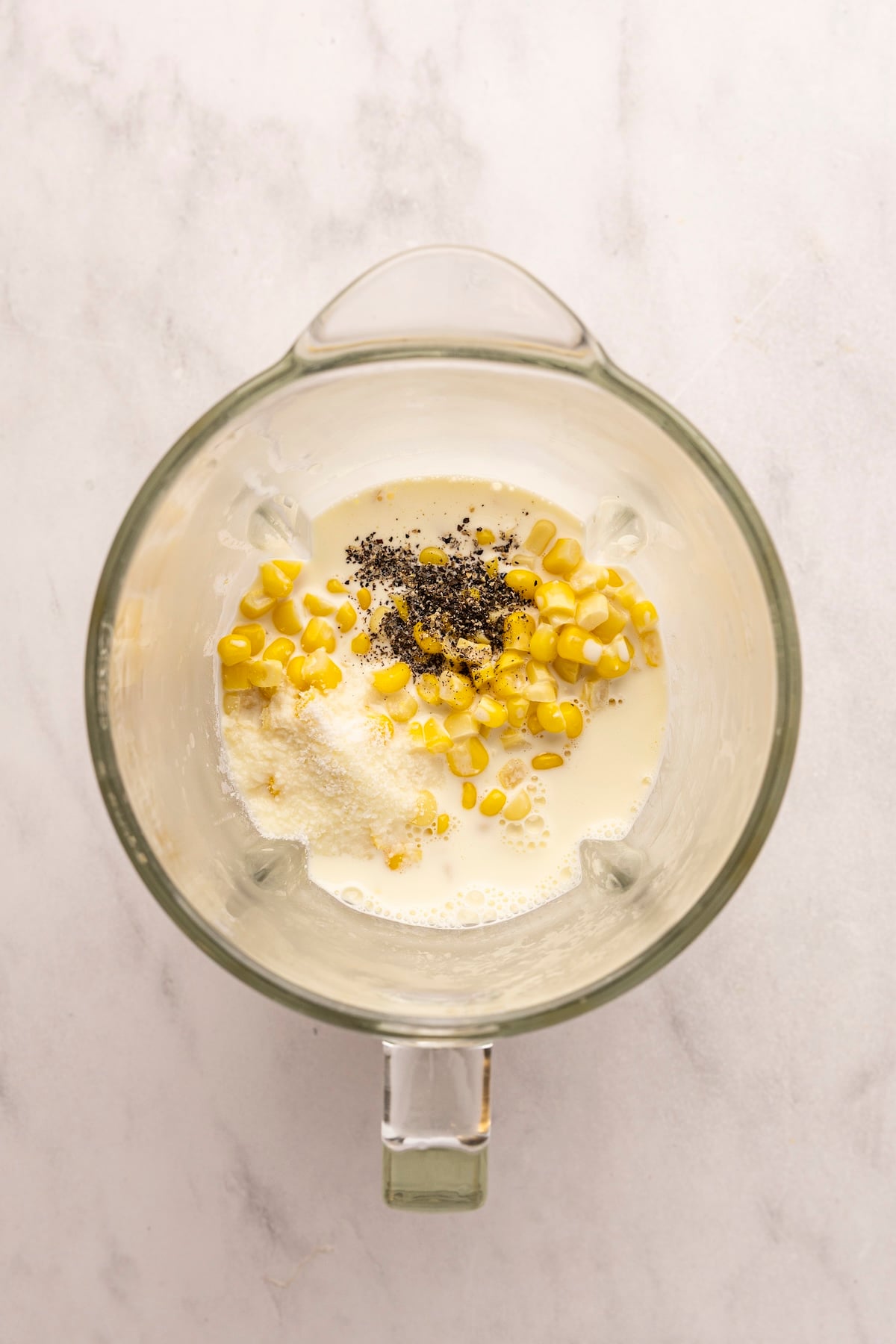 corn, corn, cream, salt, and pepper added to blender