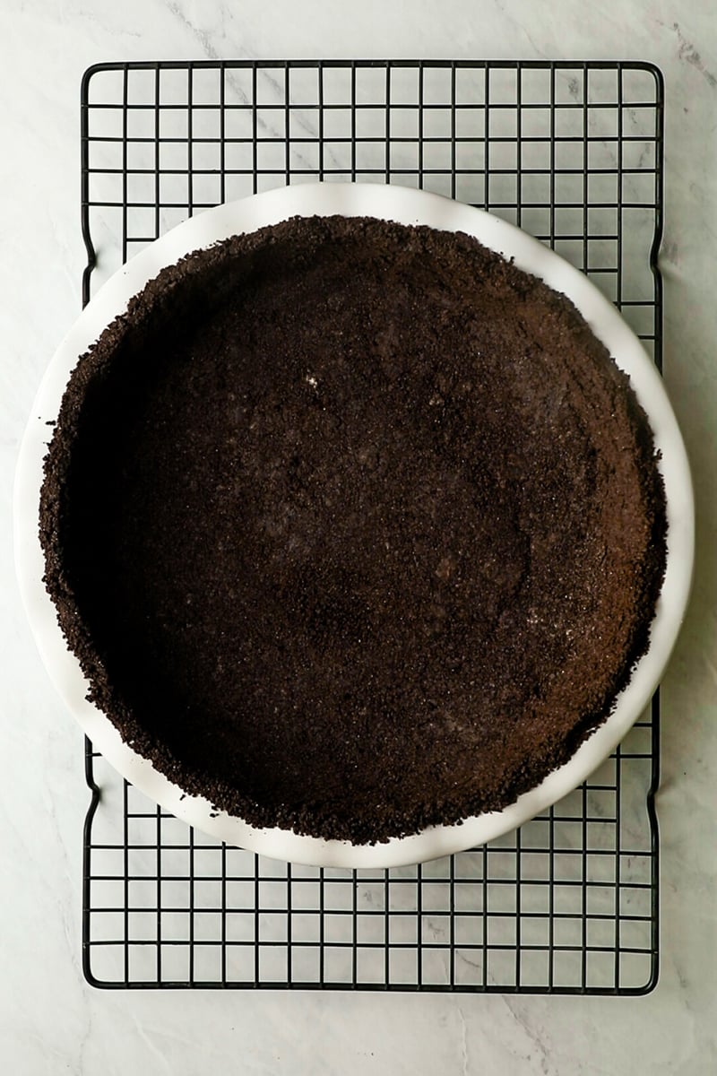 Baked Oreo crust cooling on rack.