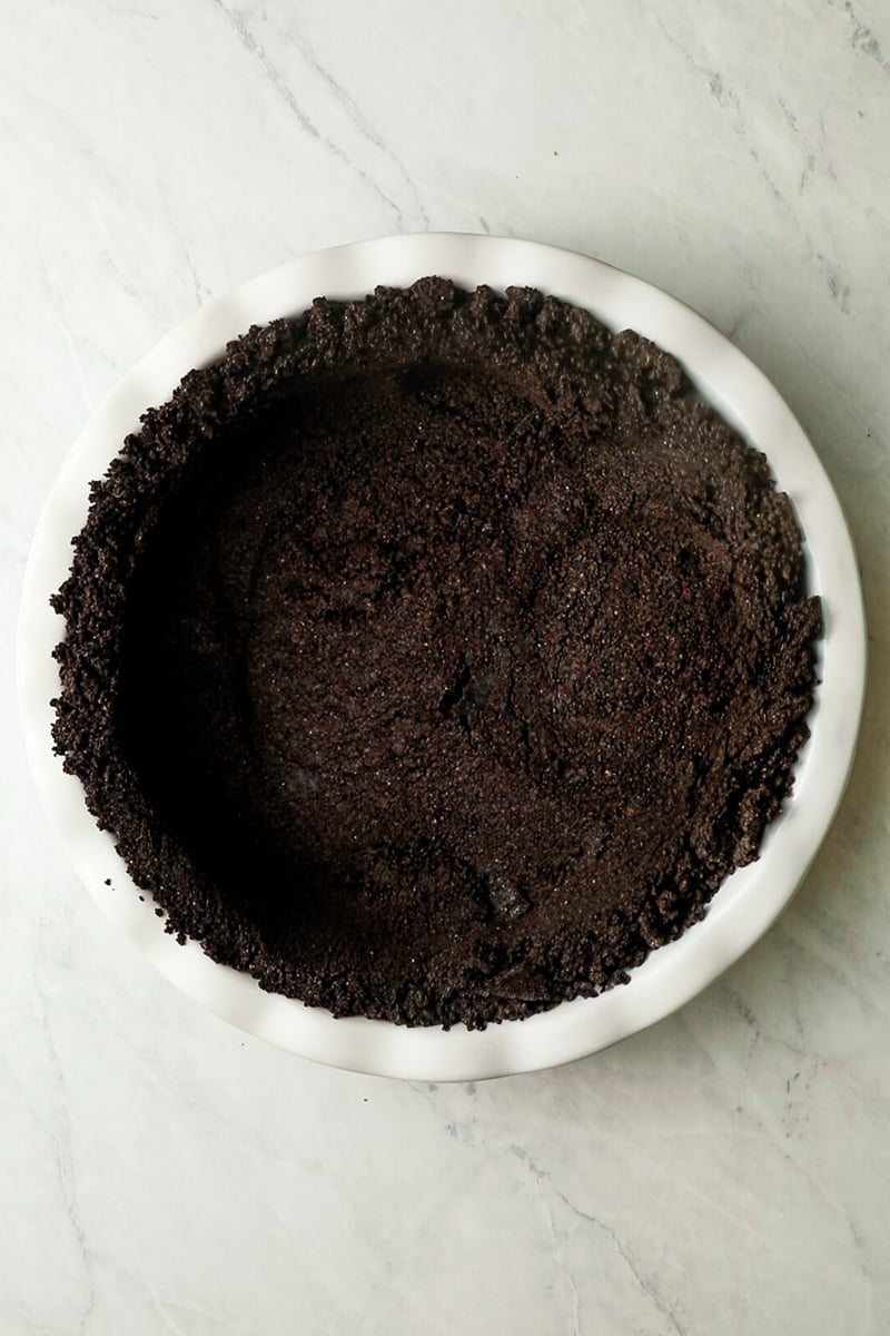 Oreo crumbs pressed into white pie pan.