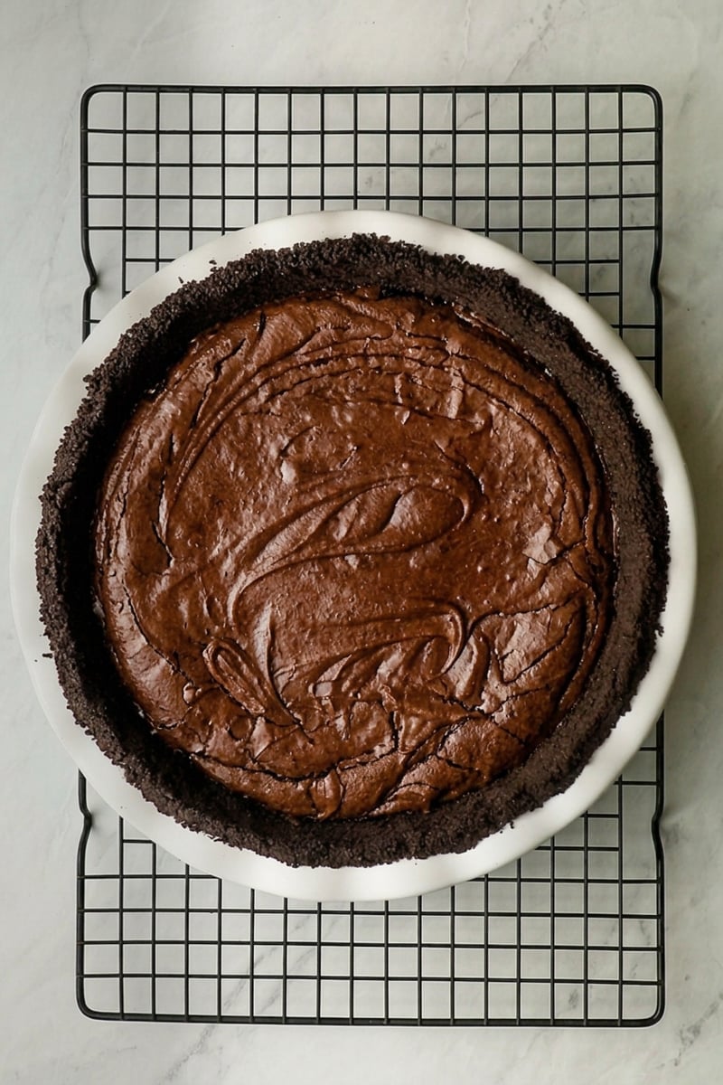 Baked brownie layer cooling on rack.