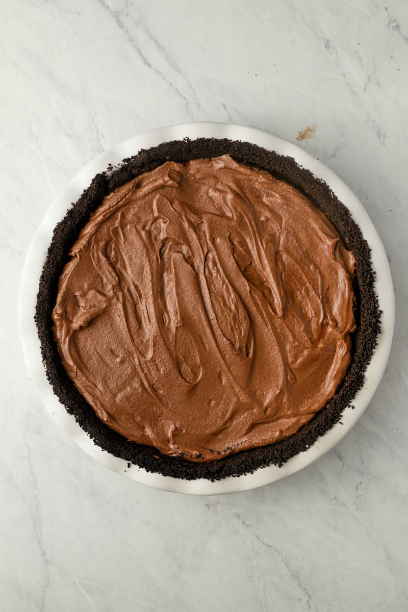 Mousse filling layered over brownie filling in Oreo crust.