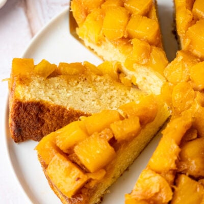 Pineapple upside-down cake sliced on platter.