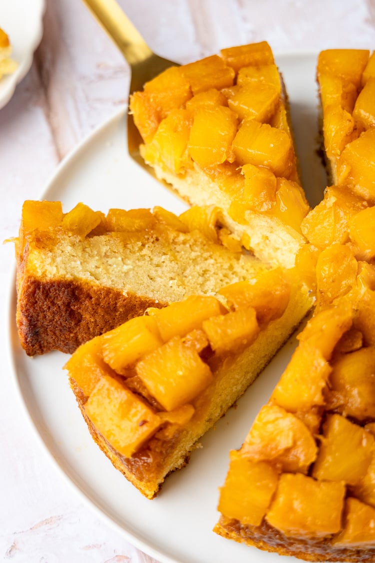 Pineapple upside-down cake sliced on platter.