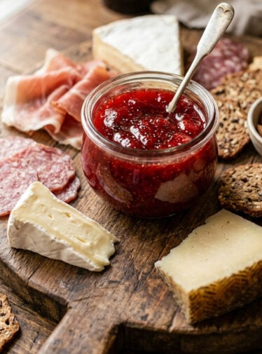 Jar of White Balsamic Strawberry Preserve with Black Pepper on charcuterie board