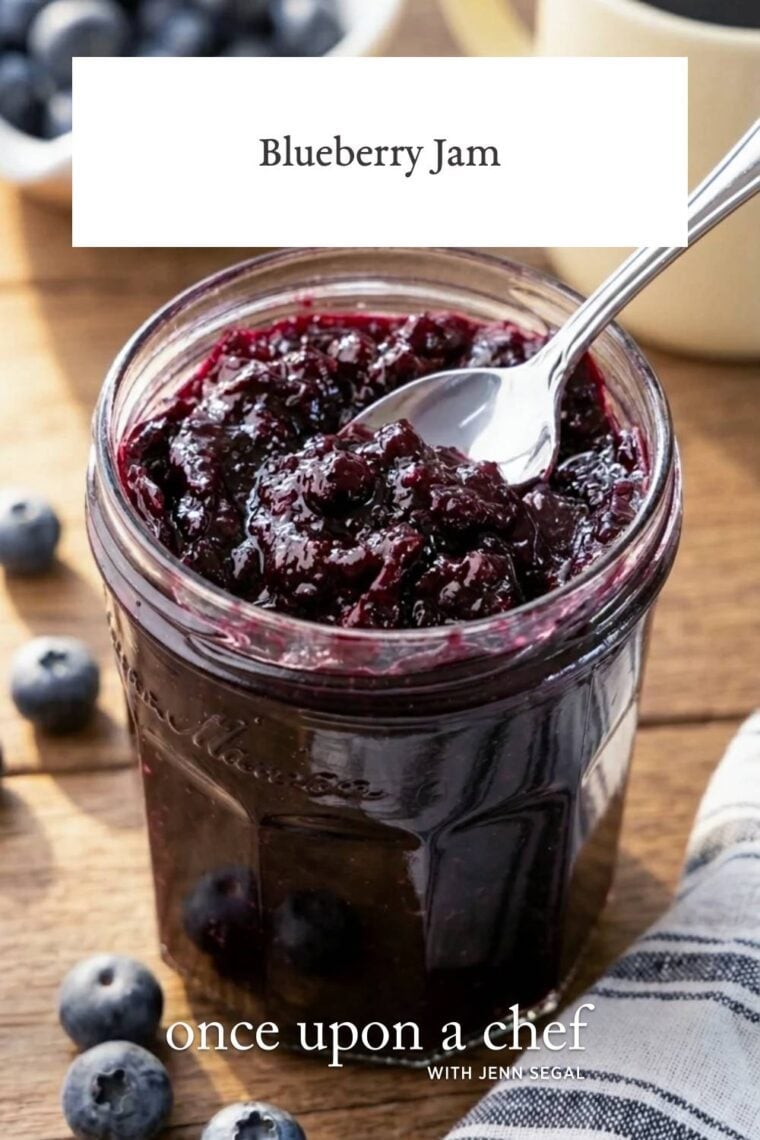 blueberry jam in jar with striped napkin next to it