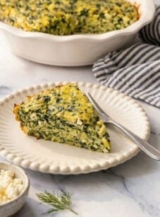 Greek spinach rice and feta pie slice on white beaded plate