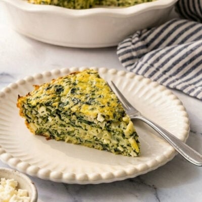 Greek spinach rice and feta pie slice on white beaded plate