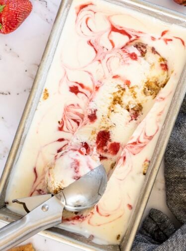 Strawberry Cheesecake Ice Cream in loaf pan with ice cream scoop