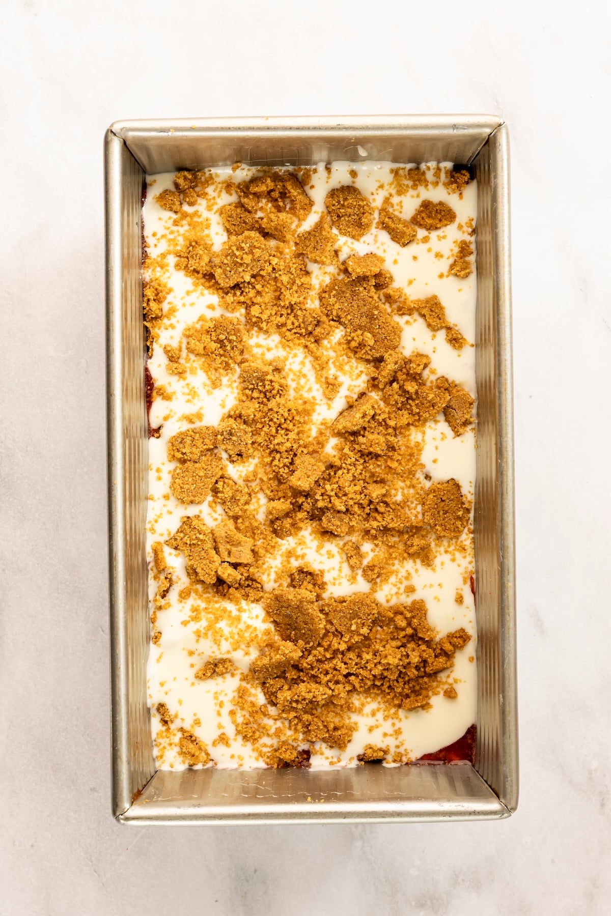 layering strawberry cheesecake ice cream in a loaf pan