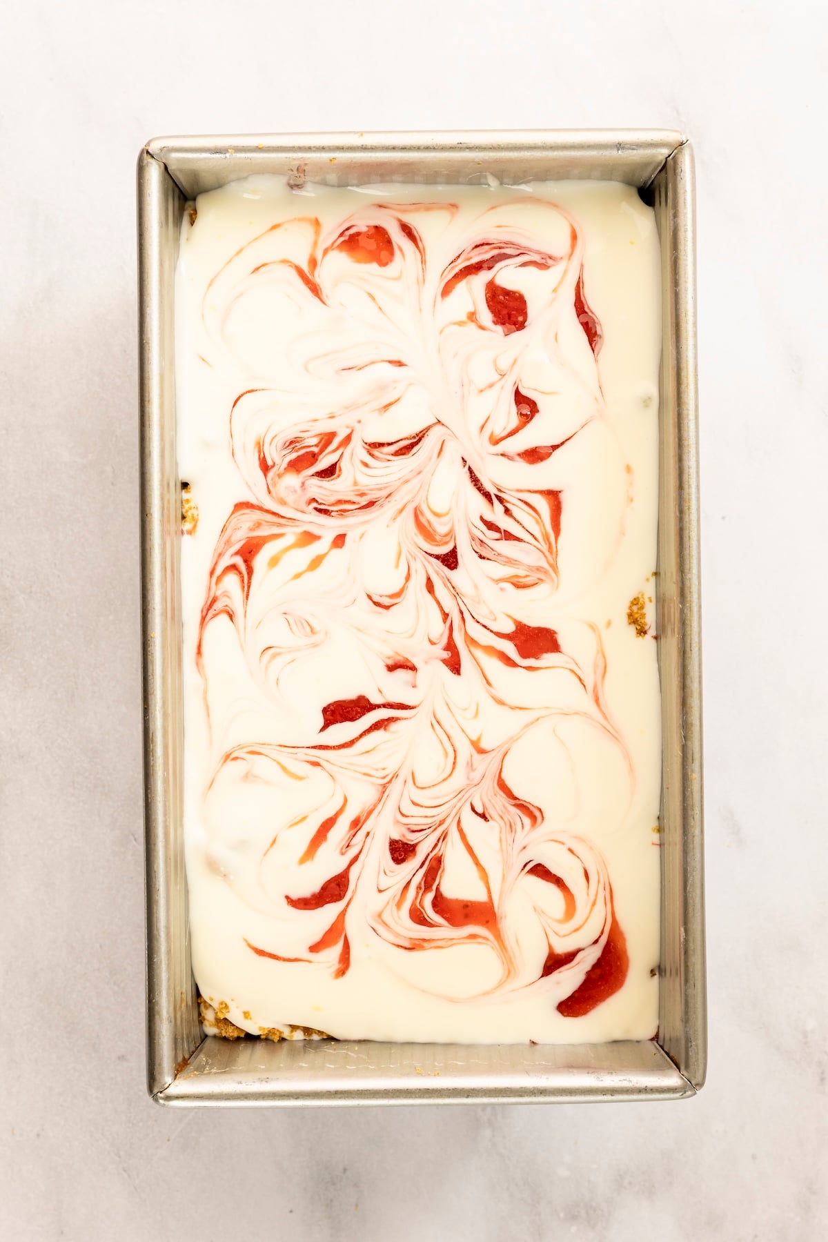 layering strawberry cheesecake ice cream in a loaf pan