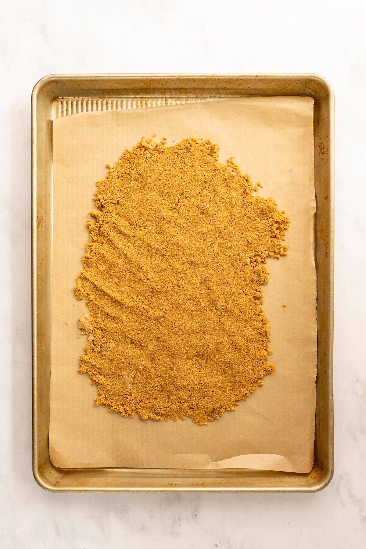 prepared baking sheet with graham cracker crust spread into even layer