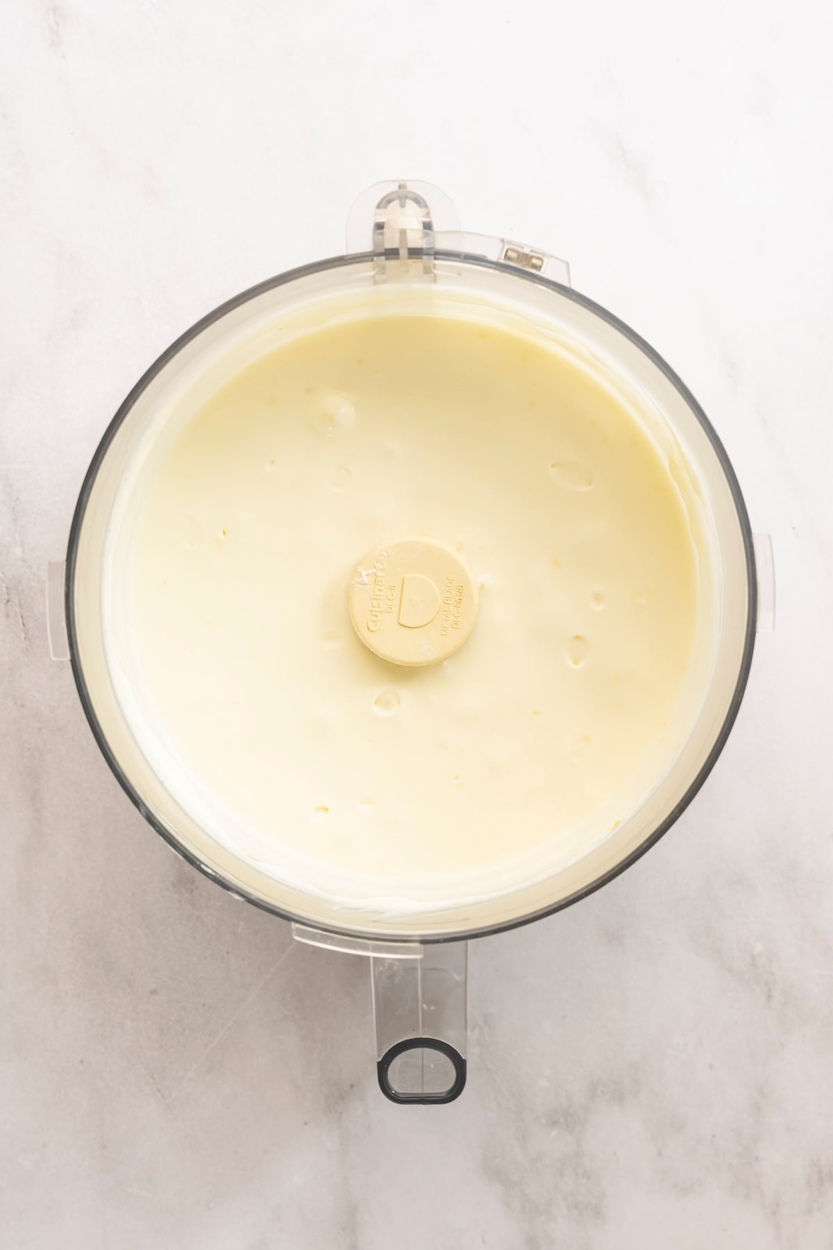food processor with heavy cream, cream cheese, sour cream, granulated sugar, lemon zest, lemon juice, and salt combined together