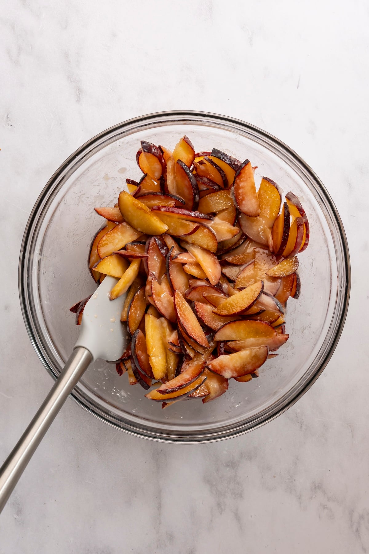 Large bowl with plums, granulated sugar, cornstarch, vanilla, and salt mixed together 