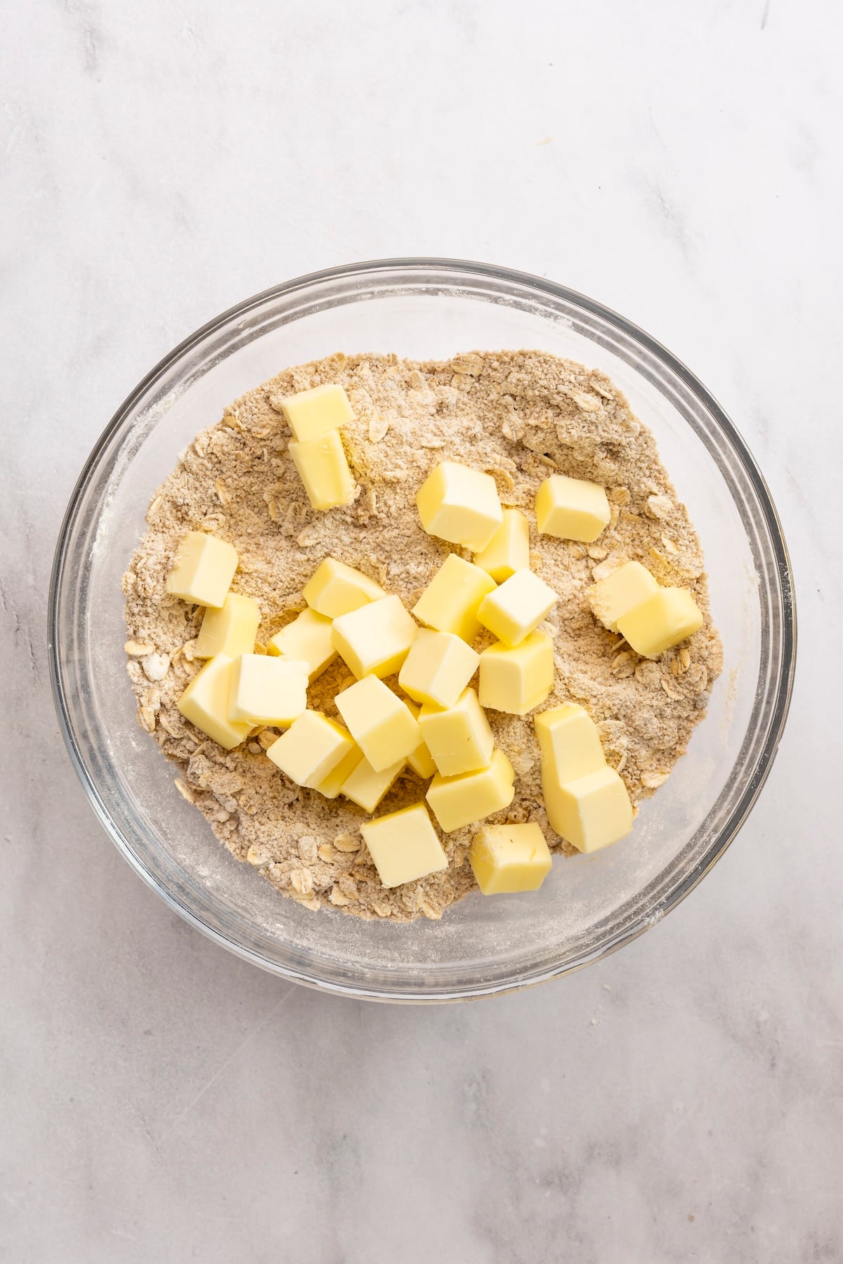 butter chunks added to medium bowl with flour/oat/brown sugar mix