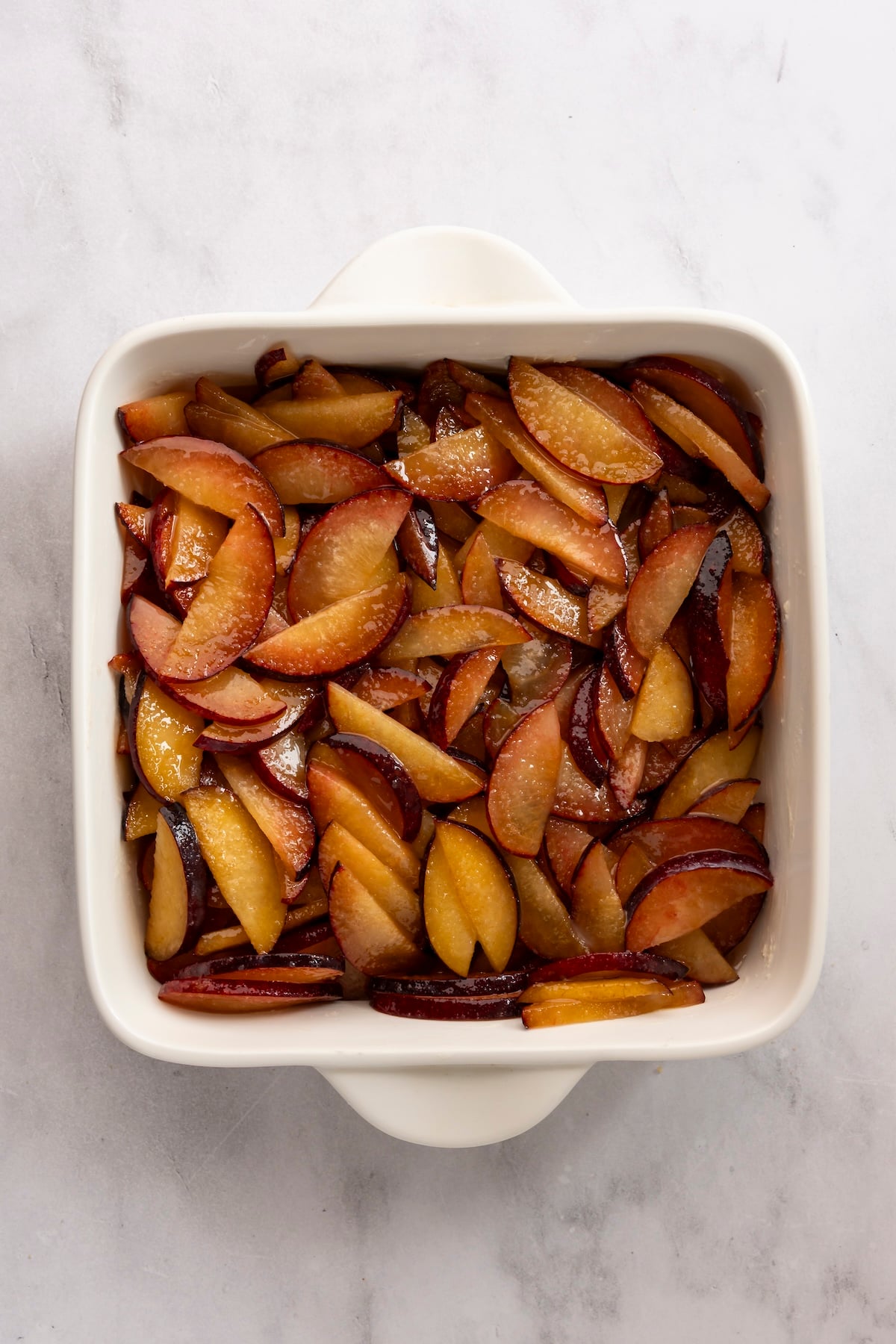 8-inch baking dish with plums in even layer