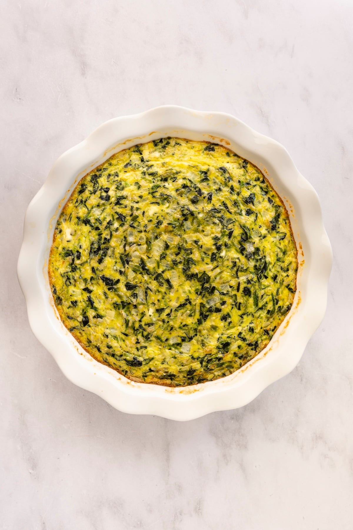 baked spinach, rice, and feta pie in pie pan