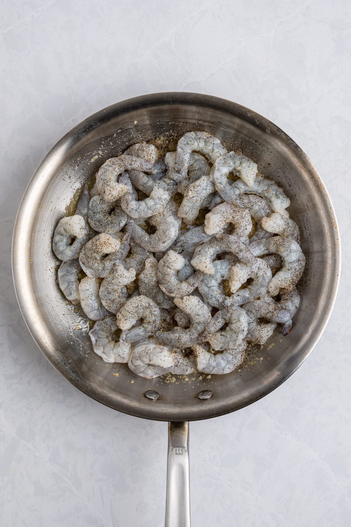 raw shimp, salt, and pepper in large skillet with cooked shallots and garlic