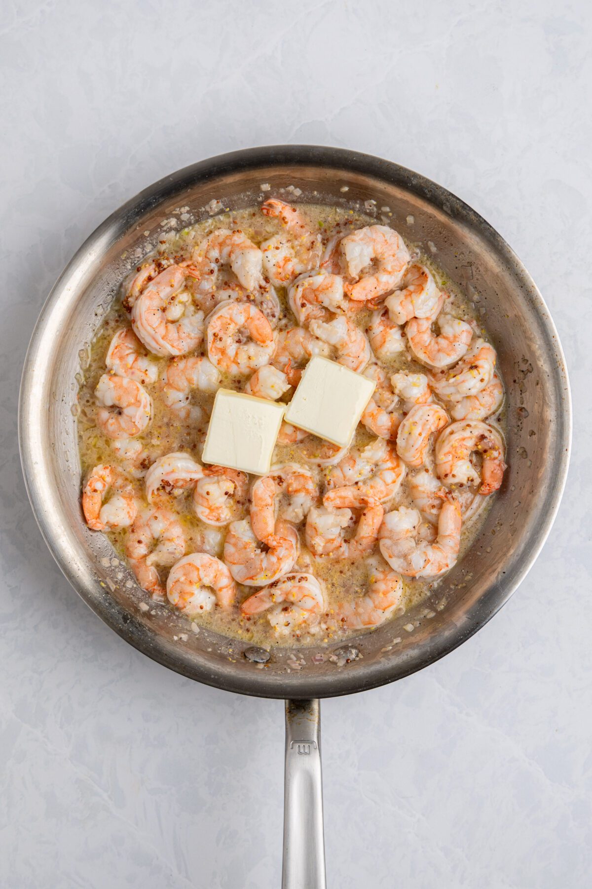 2 tablespoons of butter added to shrimp mixture in large skillet