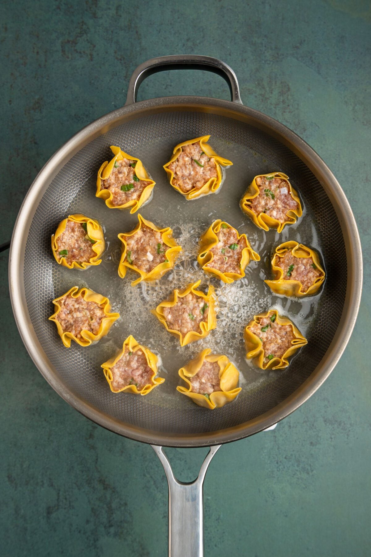Non-stick pan with dumplings and boiling water