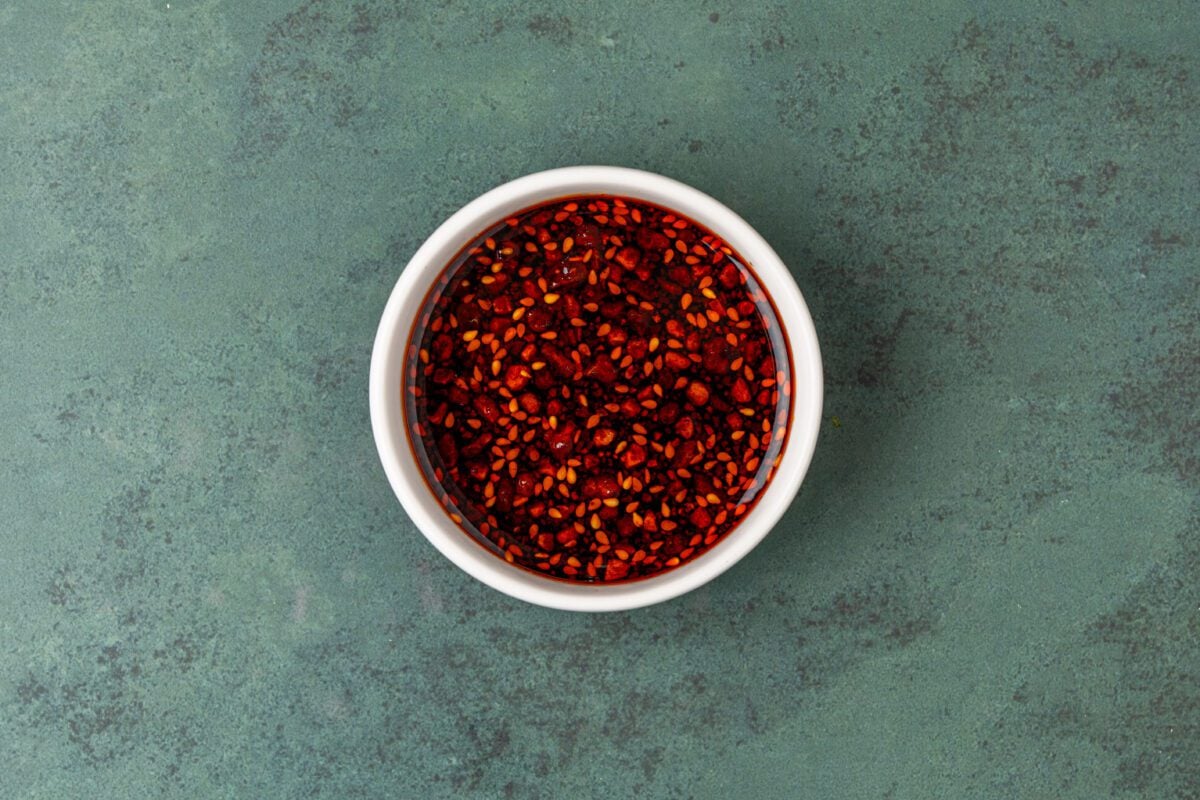 small white bowl with rice vinegar, sugar, and chili crunch
