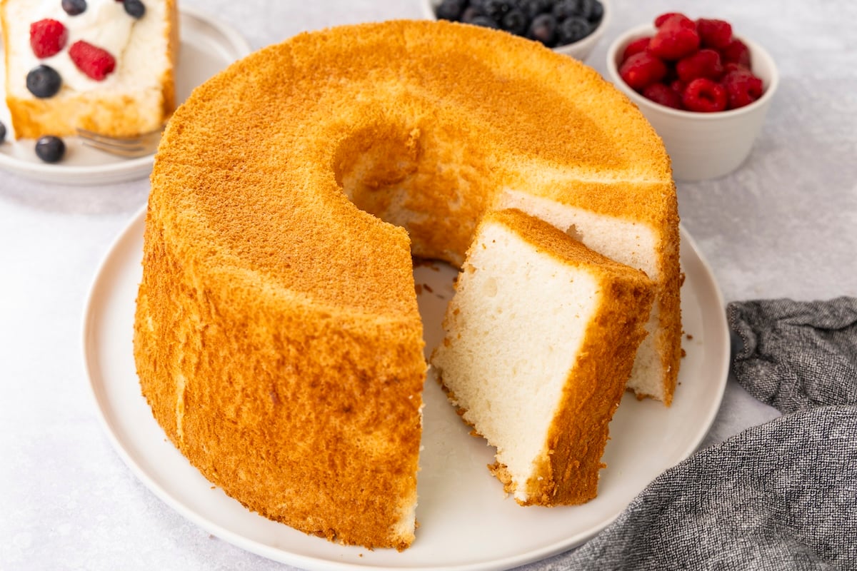Sliced angel food cake on platter with berries