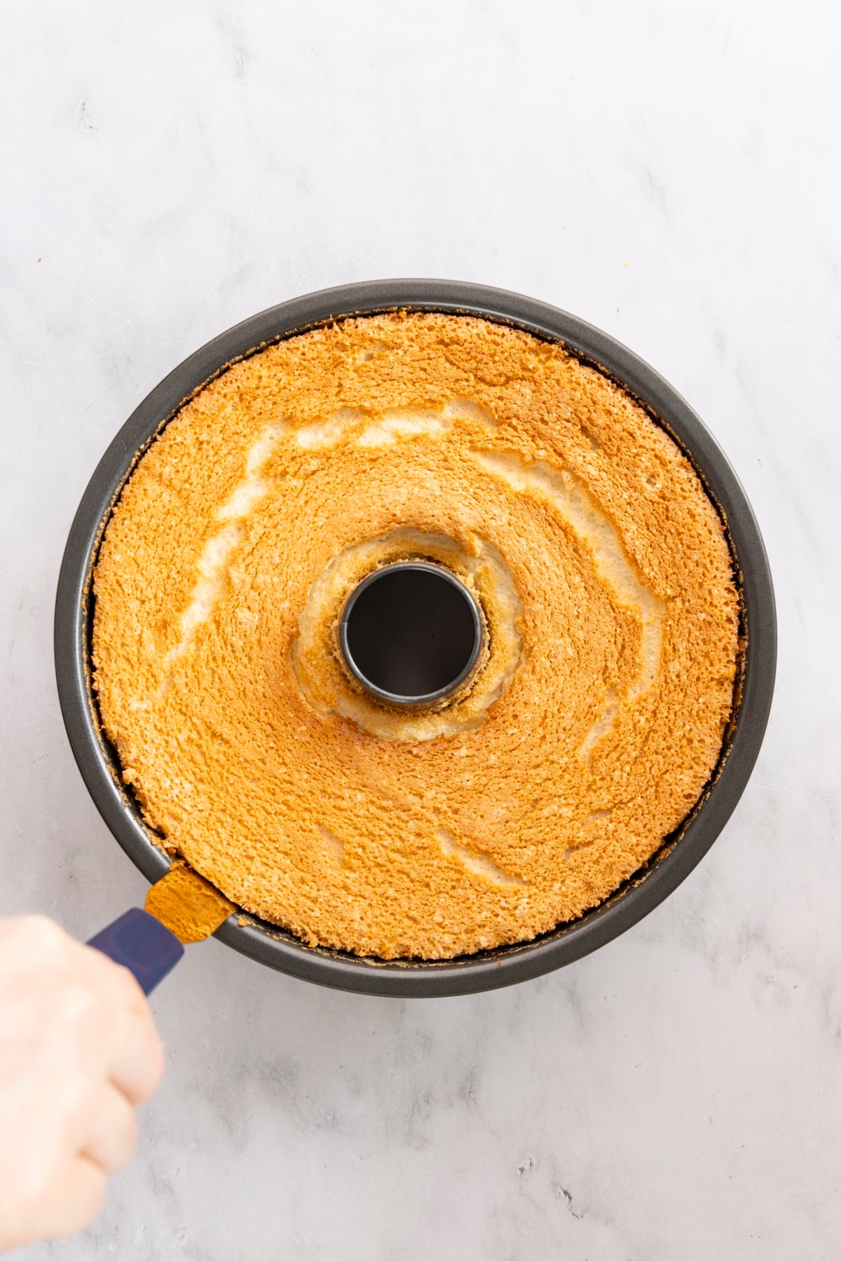 running an offset spatula around the edge of baked angel food cake