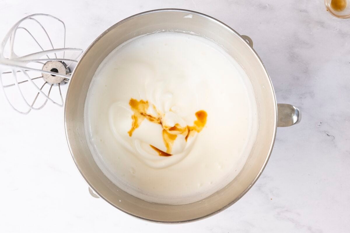mixing bowl with vanilla and almond extracts added to egg white mixture 