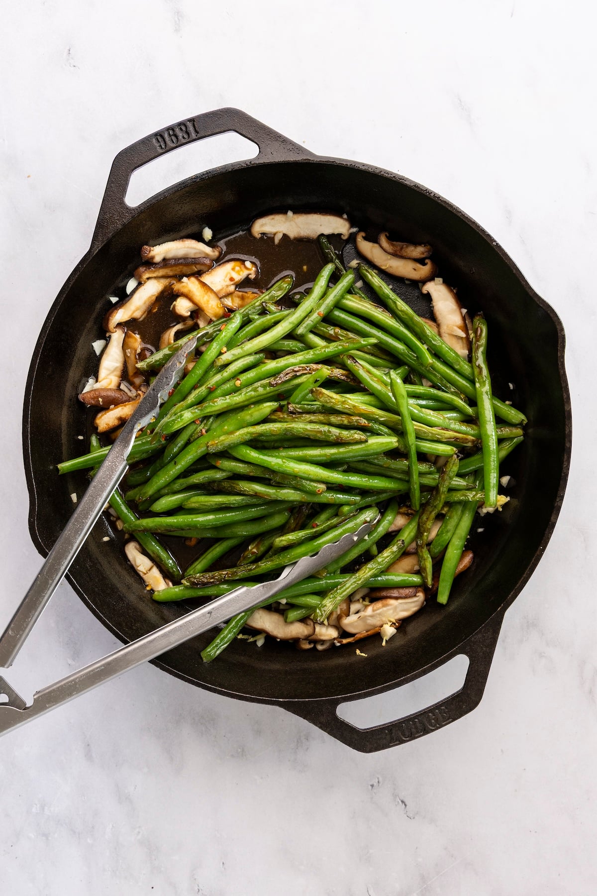 Add stir-fried green beans to mushrooms and aromatics in skillet.