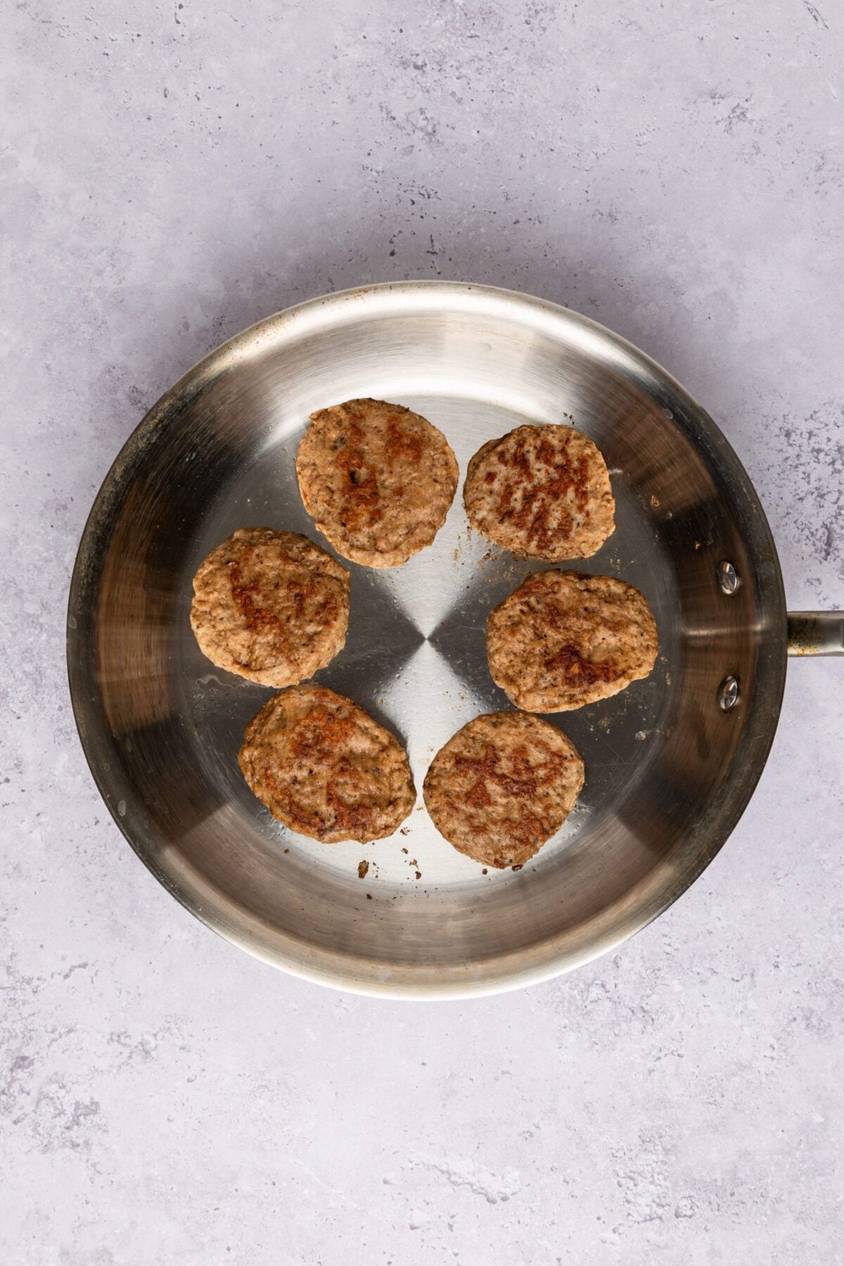 Sausage patties heating in skillet