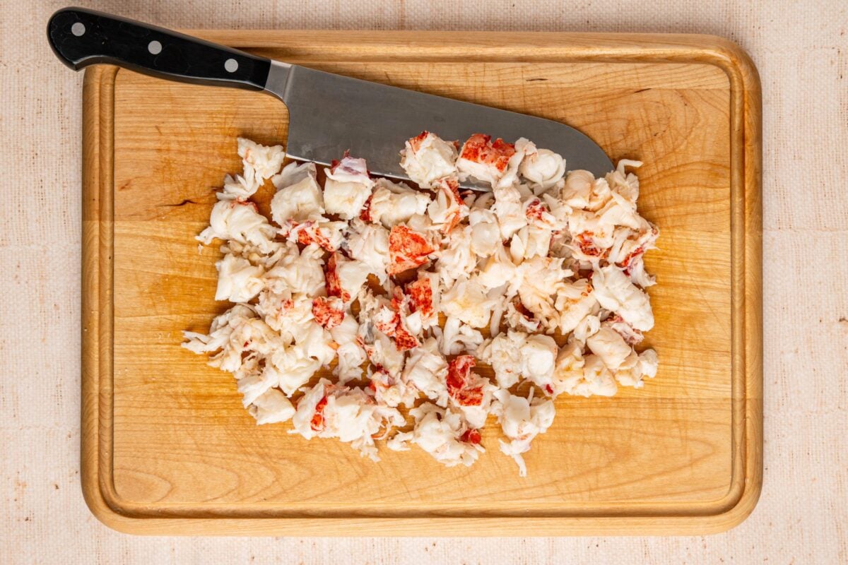 cutting board with lobster meat cut into bite-size chunks