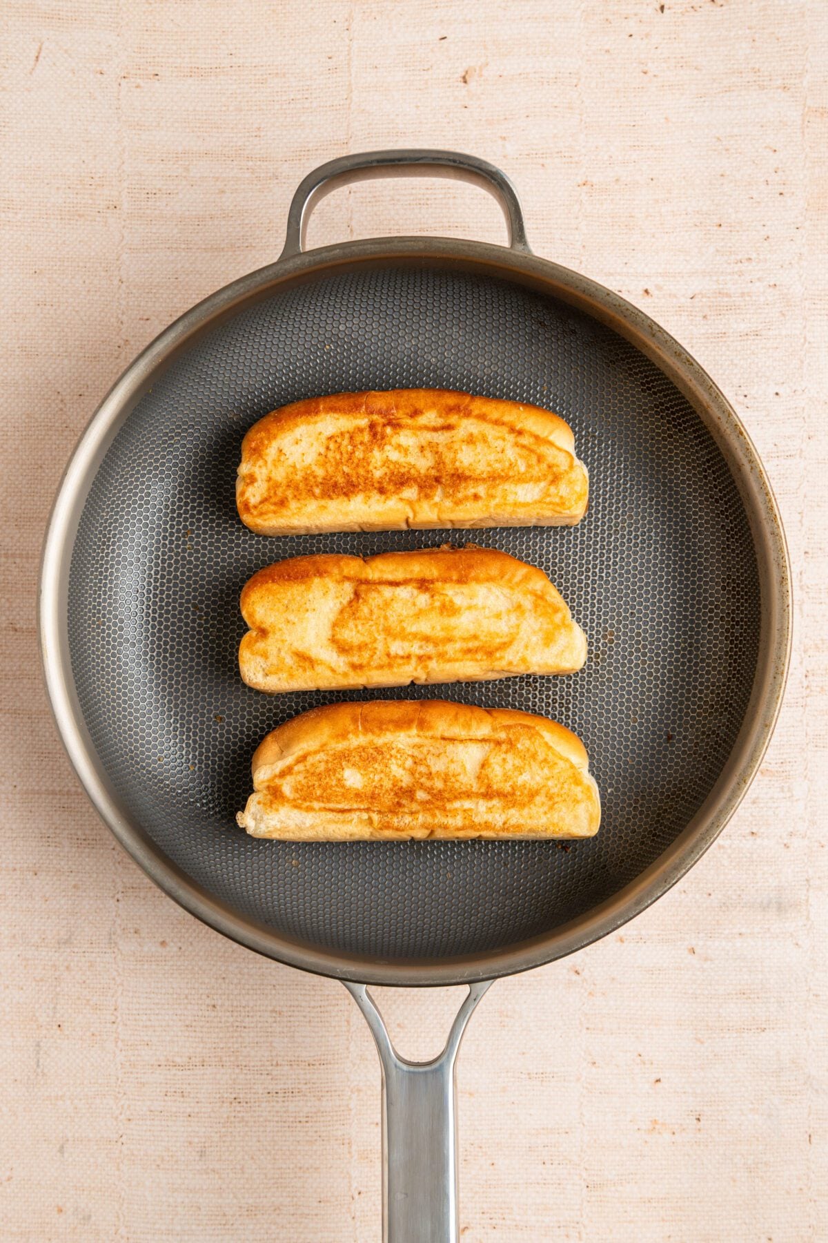 medium nonstick skillet with 3 golden brown buns