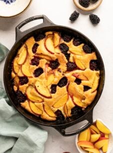 peach blackberry crumble in cast iron skillet on white counter