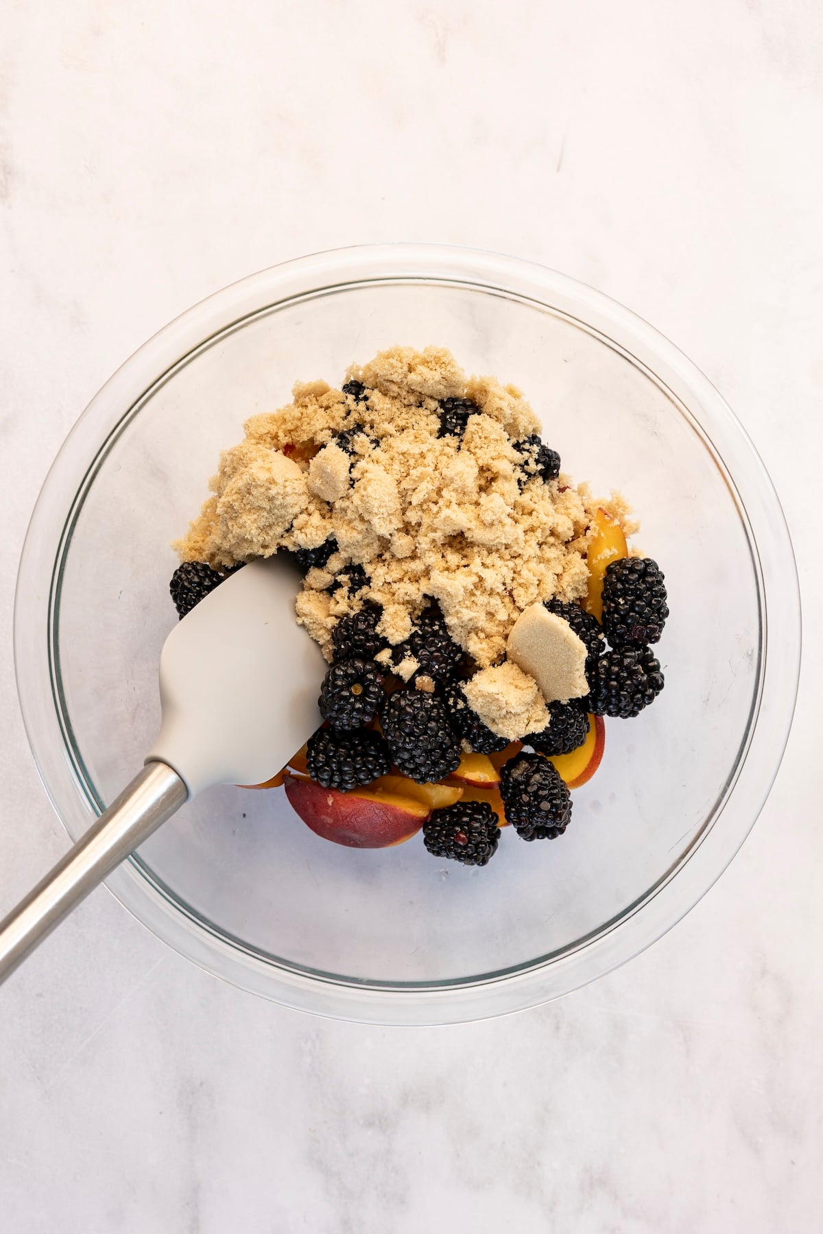 medium glass bowl with peaches, blackberries and brown sugar