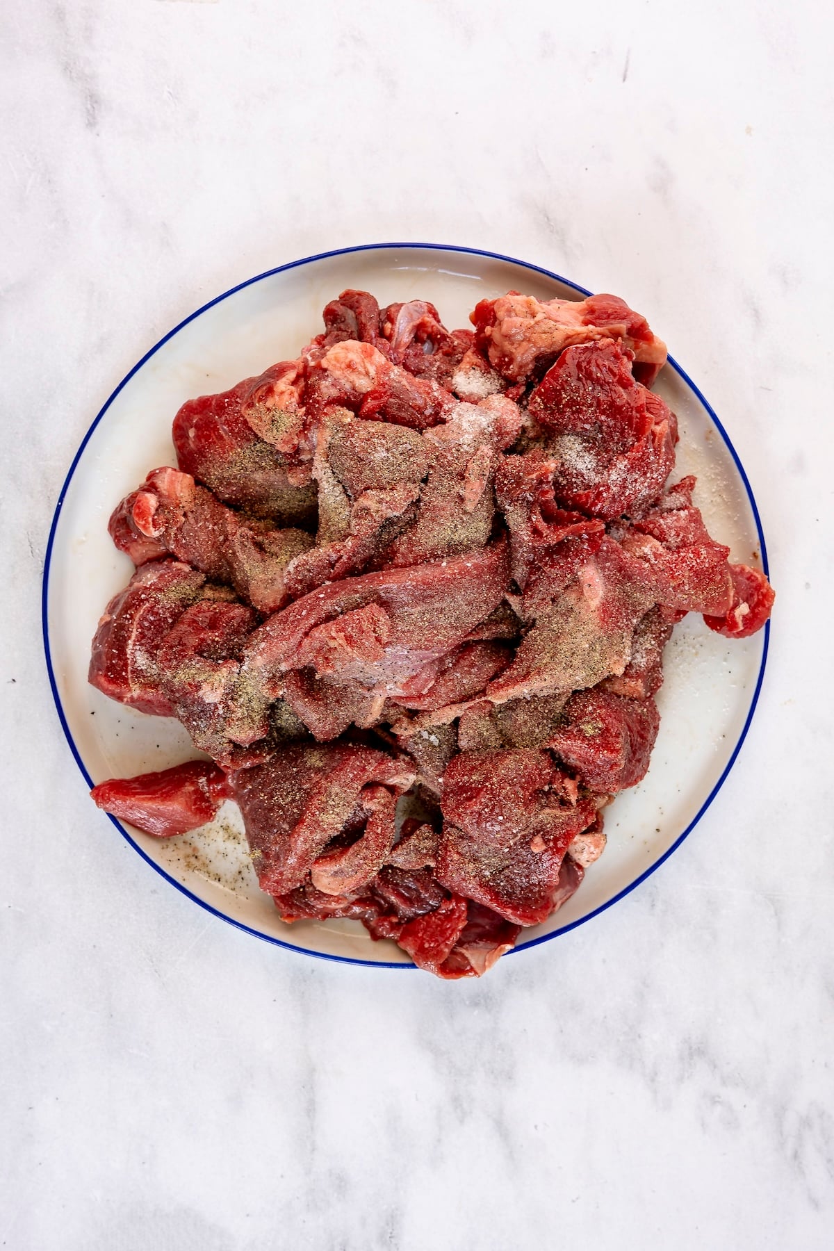 Seasoned chuck roast on plate.