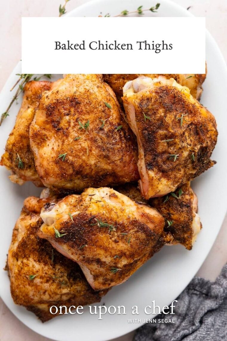 baked chicken thighs on white oval plate garnished with fresh thyme